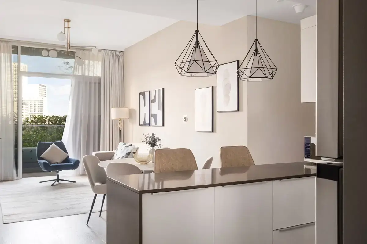 Kitchen island with pendant lights and dining chairs in a bright apartment