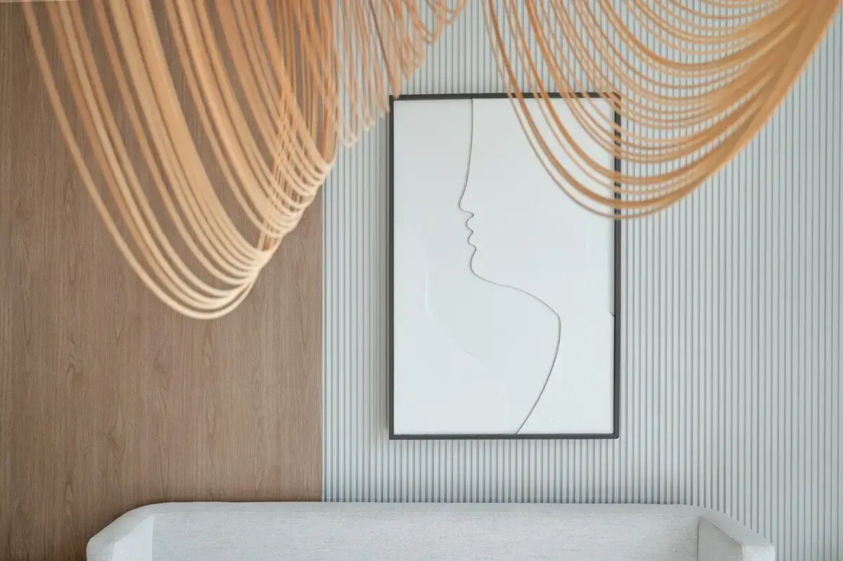 Interior detail with beige draped decor and framed line-art face print