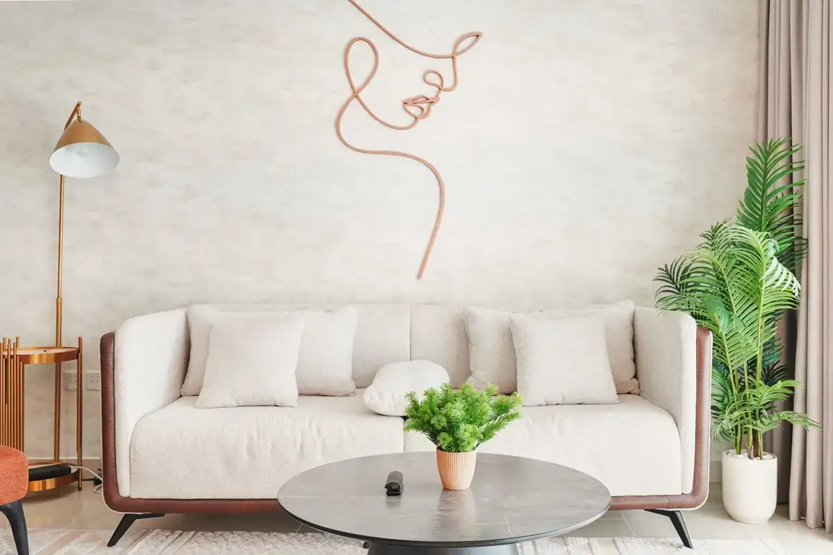 Cream sofa with round coffee table, plants and line-art wall mural